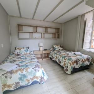 a bedroom with two beds and a window at Casa Hostal Paso por La Serena in La Serena