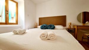 a bedroom with a bed with towels on it at Amorino Cres - Old Town House in Cres