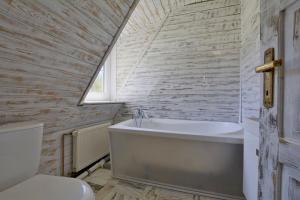 uma casa de banho com uma banheira branca e um WC. em Eco-Rajka Nowy Gierałtów 17 b em Nowy Gierałtów