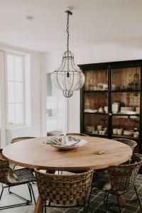 a dining room table with chairs and a chandelier at Charmeverblijf Juliette in Kasterlee