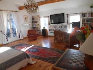a living room with a bed and a tv at Villa Boulou in Rognes