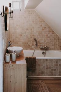 ein Badezimmer mit einem Waschbecken und einer Badewanne in der Unterkunft Charmeverblijf Juliette in Kasterlee