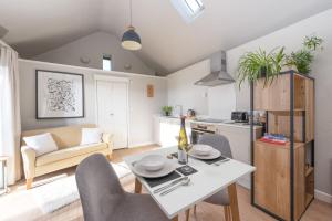 a kitchen and living room with a table and chairs at The Rest House in Porthcurno