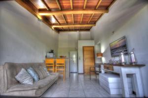 a living room with a couch and a kitchen at Village Porta do Sol Apartamento in Praia do Forte