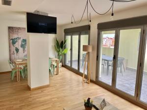 a living room with a tv on a wall and a table at Apartamento Vive Zaragoza IV in Zaragoza