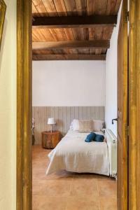 Schlafzimmer mit einem Bett mit Holzdecke in der Unterkunft LOS TILOS Casa rural en el campo. in Tordera