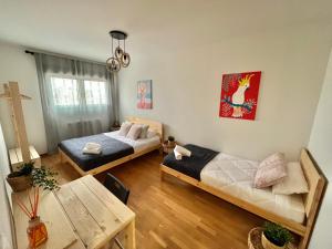 Sala de estar con 2 camas y mesa en Apartamento Vive Zaragoza IV, en Zaragoza