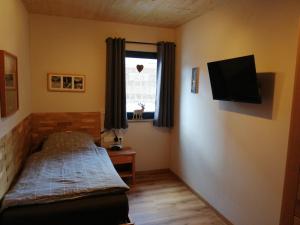 a small bedroom with a bed and a window at Hoamatgfühl in Vorderhornbach