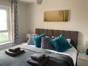 a bedroom with a large bed with blue pillows at Beautiful 2 bedroom flat overlooking golf course in Carnoustie