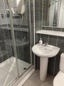 a bathroom with a sink and a shower and a toilet at Beautiful 2 bedroom flat overlooking golf course in Carnoustie