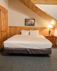 a bedroom with a large bed with white sheets at Ruttger's Bay Lake Resort in Deerwood