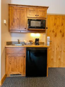 a kitchen with wooden cabinets and a black dishwasher at Ruttger's Bay Lake Resort in Deerwood