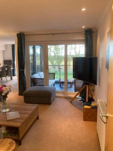 a living room with a flat screen tv and a couch at Beautiful 2 bedroom flat overlooking golf course in Carnoustie