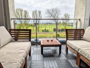 a room with two benches and a table and a window at Beautiful 2 bedroom flat overlooking golf course in Carnoustie