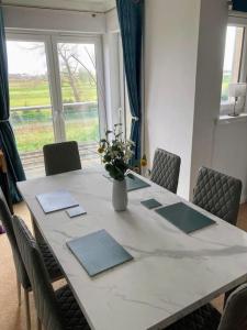 uma mesa de jantar com um vaso de flores em Beautiful 2 bedroom flat overlooking golf course em Carnoustie