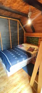 Cama en habitación con techo de madera en Alpina Glamping en Latacunga, en Saquisilí