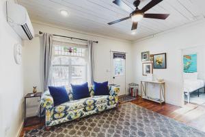 a living room with a couch and a ceiling fan at The Pink House on Main - Lower in Eureka Springs