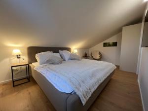 sypialnia z dużym łóżkiem z białą pościelą i poduszkami w obiekcie Cecilienpark Oberharz w mieście Hahnenklee-Bockswiese
