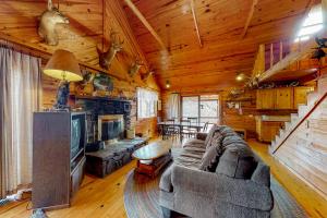 a living room with a couch and a tv in a cabin at Charlie's Ol' Fishing Cabin in Eureka Springs
