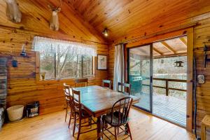 a dining room with a wooden table and chairs at Charlie's Ol' Fishing Cabin in Eureka Springs +11 photos