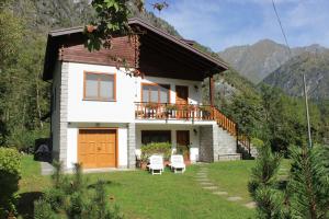 a small white house with a balcony and two chairs at Villa Egle in Antronapiana