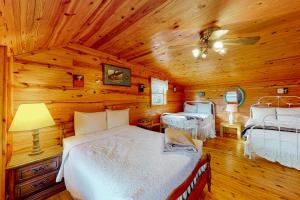 a bedroom with two beds in a wooden cabin at Charlie's Ol' Fishing Cabin in Eureka Springs