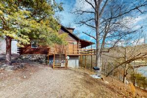 a log cabin with a staircase leading up to it at Charlie's Ol' Fishing Cabin in Eureka Springs