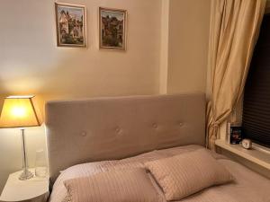 a bedroom with a bed with a lamp and a window at Oslo City Apartment in Oslo