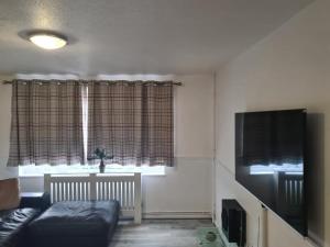 a living room with a couch and a window at Luxury House, 4 bedrooms fully furnished in North Woolwich