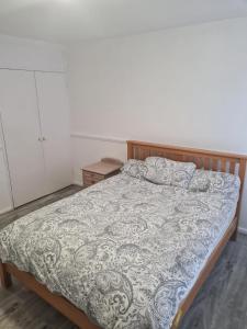 um quarto com uma cama grande e um cobertor em Luxury House, 4 bedrooms fully furnished em North Woolwich