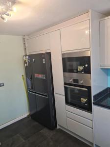 a kitchen with two refrigerators and a stove at Luxury House, 4 bedrooms fully furnished in North Woolwich