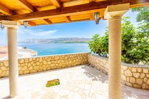 eine Terrasse mit einer Steinmauer und Blick auf das Wasser in der Unterkunft Marva stylish Mediterranean accomodation with beautiful view in Zubovići