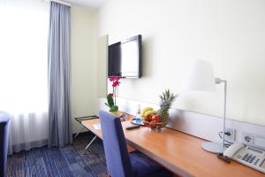 a hotel room with a desk with a computer on it at Senator Hotel in Frankfurt/Main