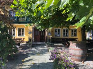 ein gelbes Haus mit einem Fass davor in der Unterkunft Gasthaus Marienhof in Kirchdorf am Inn