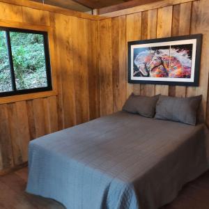 een slaapkamer met een bed en een foto aan de muur bij Zen Oasis del Bosque, ¡A place to reconnect! in Calima