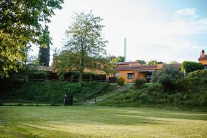 una casa en una colina con un patio de hierba en La BERBENA casa rural en el campo, en Tordera