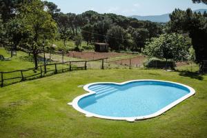 uma pequena piscina azul num campo relvado em La BERBENA casa rural en el campo em Tordera