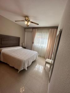 a bedroom with a bed and a ceiling fan at Agradable casa con piscina in Bolnuevo