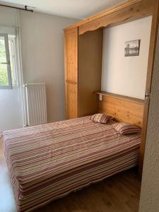 una camera da letto con un letto grande con struttura in legno di T3 idéal ski et randonnée en famille a Cauterets