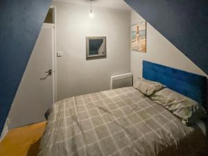 a bedroom with a bed with a blue headboard at 2 Bed Central Hub in Medway in Chatham