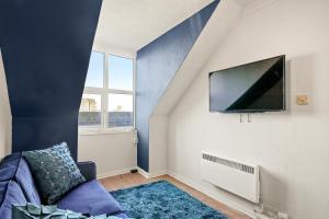 sala de estar con sofá y TV en la pared en 2 Bed Central Hub in Medway en Chatham