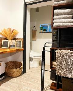 a bathroom with a toilet and a shelf with towels at ENSO Residence 古民家一棟貸切宿 東近江市五個荘 ペット可 定員6名 in Higashiomi