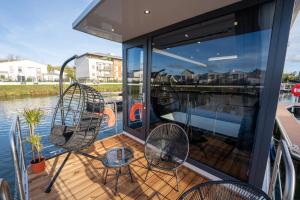 a balcony with chairs and tables on a boat at L'Escale Royale L'Isle Adam à 20 minutes de Paris CDG in LʼIsle-Adam