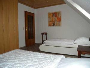 1 dormitorio con 2 camas, mesa y puerta en Trassenheide Strandgalopp am Walde Wohnung W1TE en Trassenheide