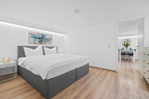 een witte slaapkamer met een groot bed en een tafel bij Ferien-Apartment Zaunkönig - mit priv Strandzugang in Friedrichshafen +21 foto's