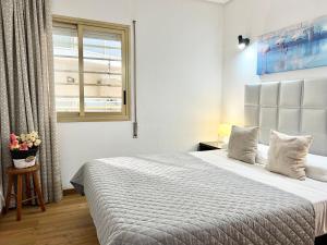 - une chambre avec un grand lit et une fenêtre dans l'établissement Apartamentos Centro, à Salou