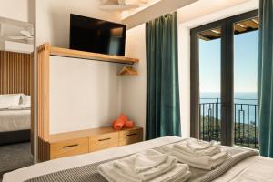 a bedroom with a bed and a view of the ocean at Mani Theasis in Stoupa