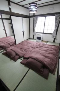 a bedroom with a large bed in a room with windows at TsukisamuFukuya / Vacation STAY 2141 in Sapporo