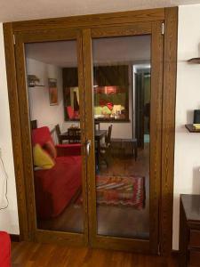 eine Glasschiebetür im Wohnzimmer mit Sofa in der Unterkunft Appartamento + box a Cervinia con vista in Breuil-Cervinia