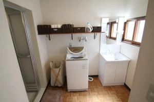 a small bathroom with a sink and a washing machine at TsukisamuFukuya / Vacation STAY 2141 in Sapporo